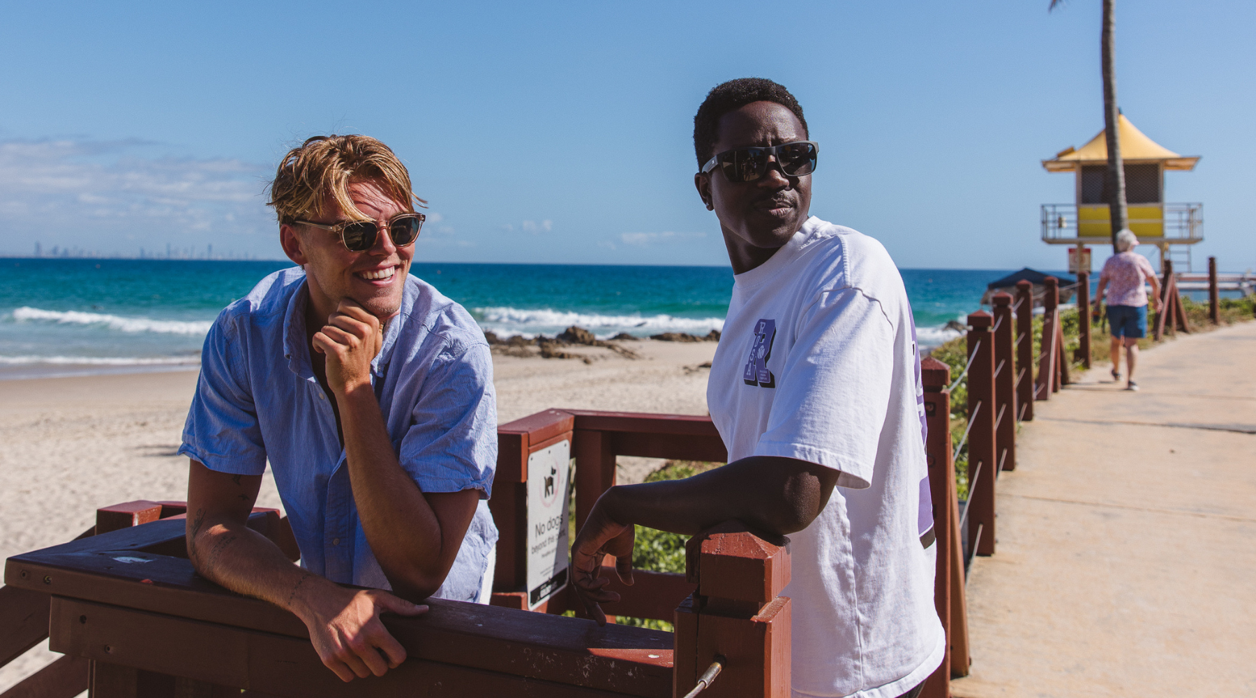 two men wearing sunglasses by the ocean