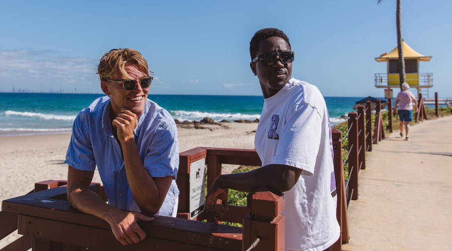 two men wearing sunglasses by the ocean