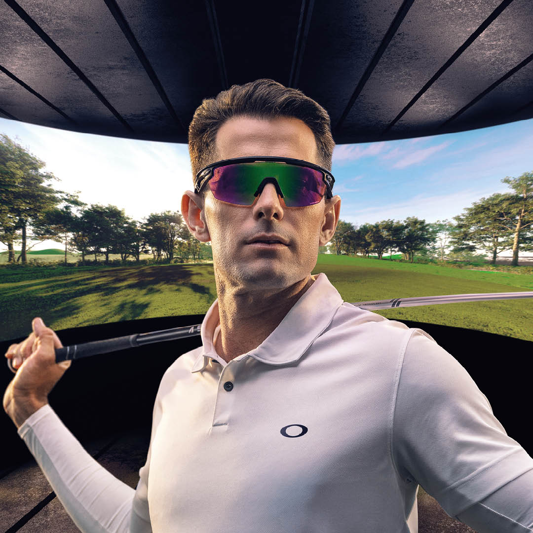 Man wearing Oakley sunglasses and a white shirt playing golf