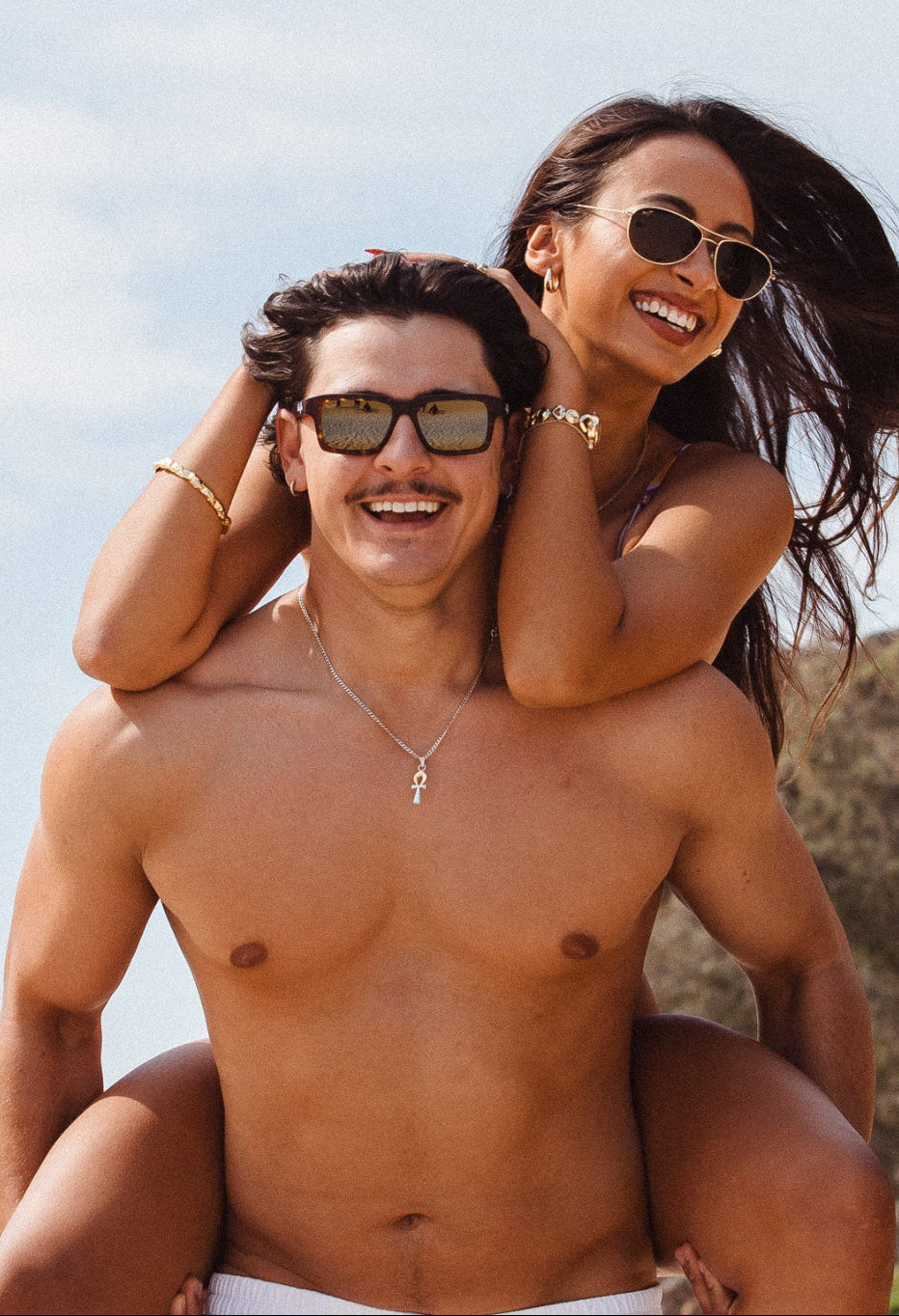 Girl and boy on the beach wearing maui jim sunglasses