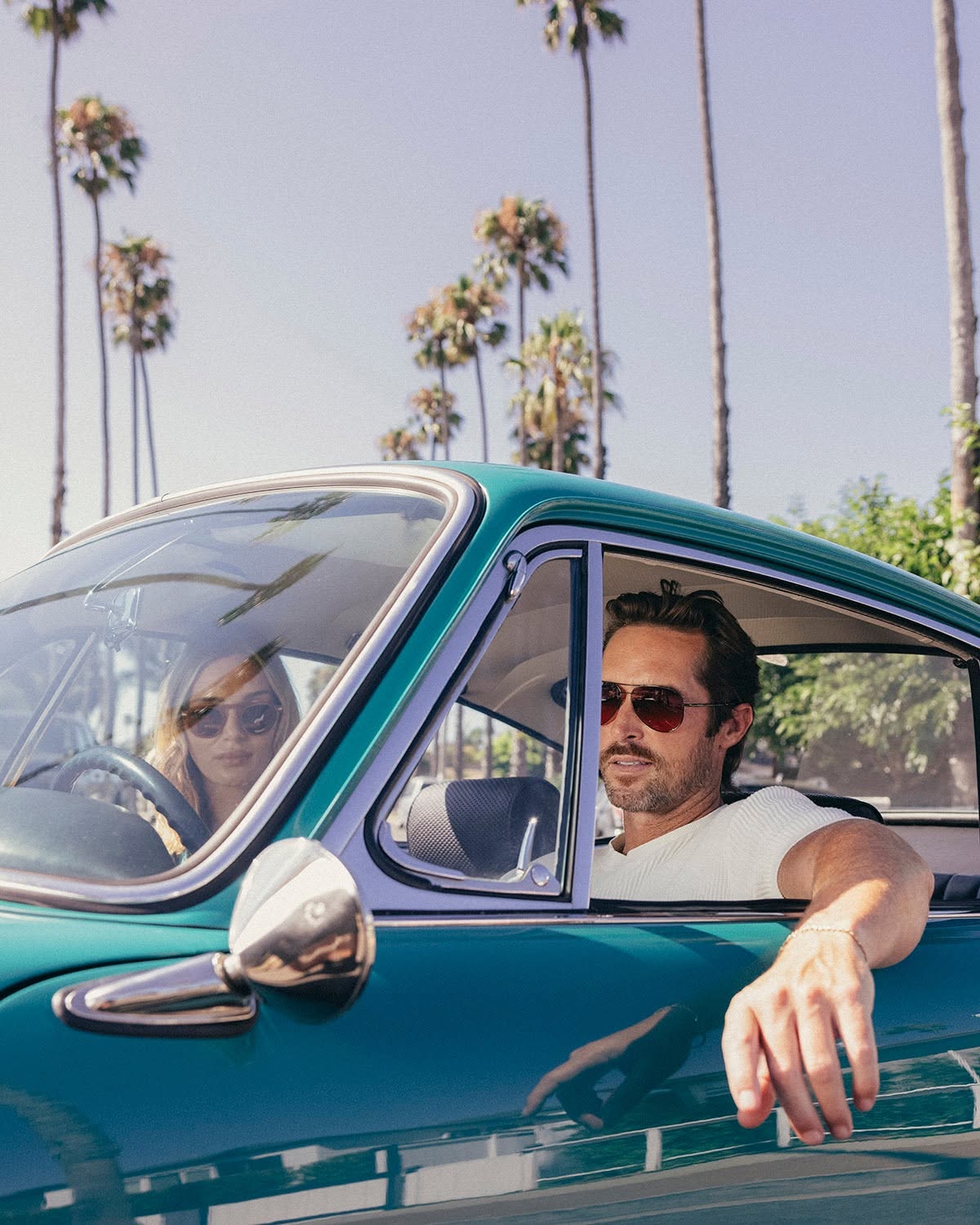 Couple driving wearing Serengeti sunglasses